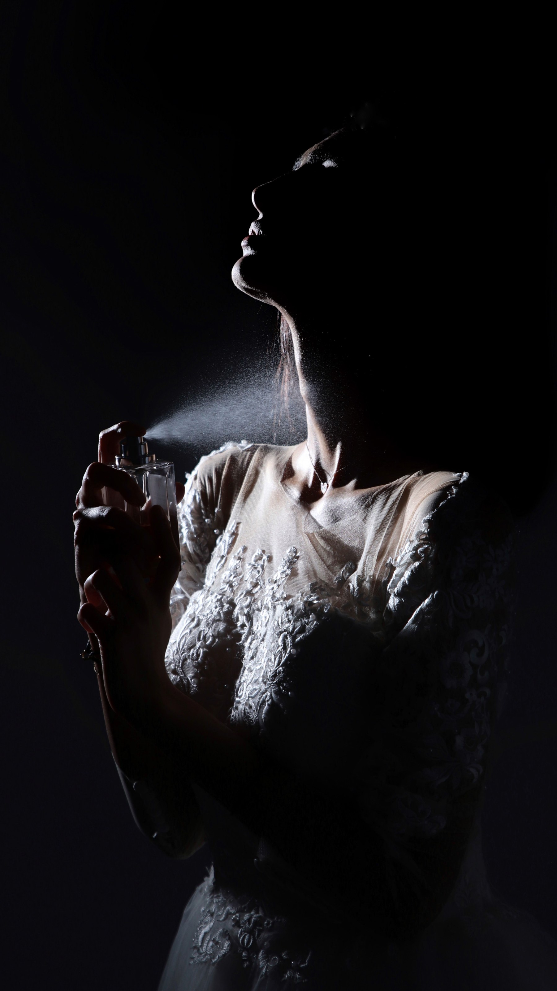 A hand reaching through a dark field of light.